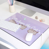 Pusheen Desk Mat shown with a keyboard and mouse to demonstrate the size and scale of the purple laminated mat.