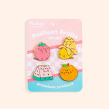 Pusheen Fruits Pin Set on a yellow background. Pusheen the Cat takes the form of a strawberry, banana, watermelon slice, and orange. The features of the pins are outlined in a shiny gold finish.