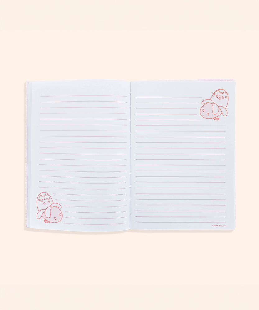 Interior view of the plush notebook. The inside cover features a pink checkered print with bananas and Pusheen Bananas in a scattered pattern.