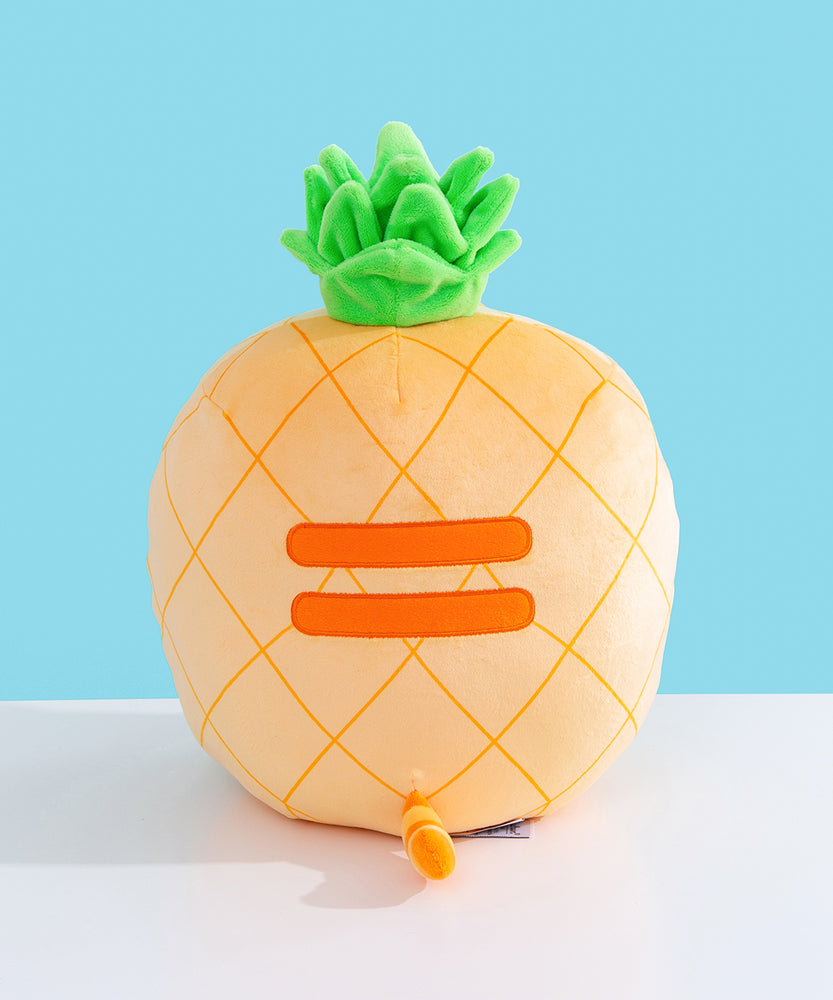 Back view of the Pineapple Squisheen Plush. The darker yellow grid pattern extends fully around the plush. On the back of the plush are embroidered darker yellow stripes to mimic Pusheen’s classic back stripes. Extending off the bottom back of the Pusheen is a yellow and darker yellow striped tail. 