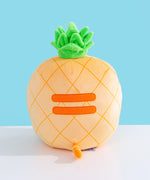 Back view of the Pineapple Squisheen Plush. The darker yellow grid pattern extends fully around the plush. On the back of the plush are embroidered darker yellow stripes to mimic Pusheen’s classic back stripes. Extending off the bottom back of the Pusheen is a yellow and darker yellow striped tail. 