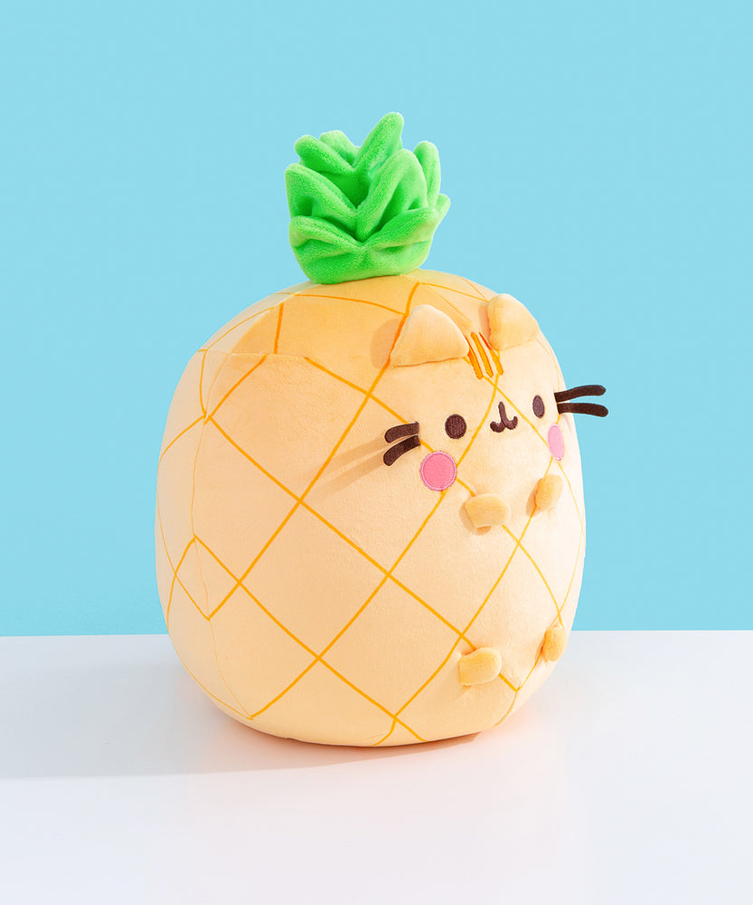 Side quarter view of the plush. The plush sits upright while Pusheen’s four paws extend off the front of the plush and do not touch the tabletop surface the plush is sitting on. 