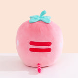 Back view of the Strawberry Squisheen Plush. On the back of the plush are embroidered red stripes to mimic Pusheen’s classic back stripes. Extending off the bottom back of the Pusheen is a pink and red striped tail. 