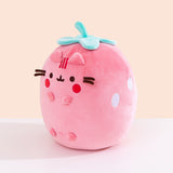 Side quarter view of the plush. The plush sits upright while Pusheen’s four paws extend off the front of the plush and do not touch the tabletop surface the plush is sitting on. 