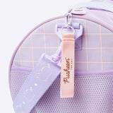 Close-up of the pink zipper pull on the Pusheen travel bag. The zipper pull has the Pusheen the Cat text logo while the removable shoulder strap has the cat logo repeatedly printed down the strap. 