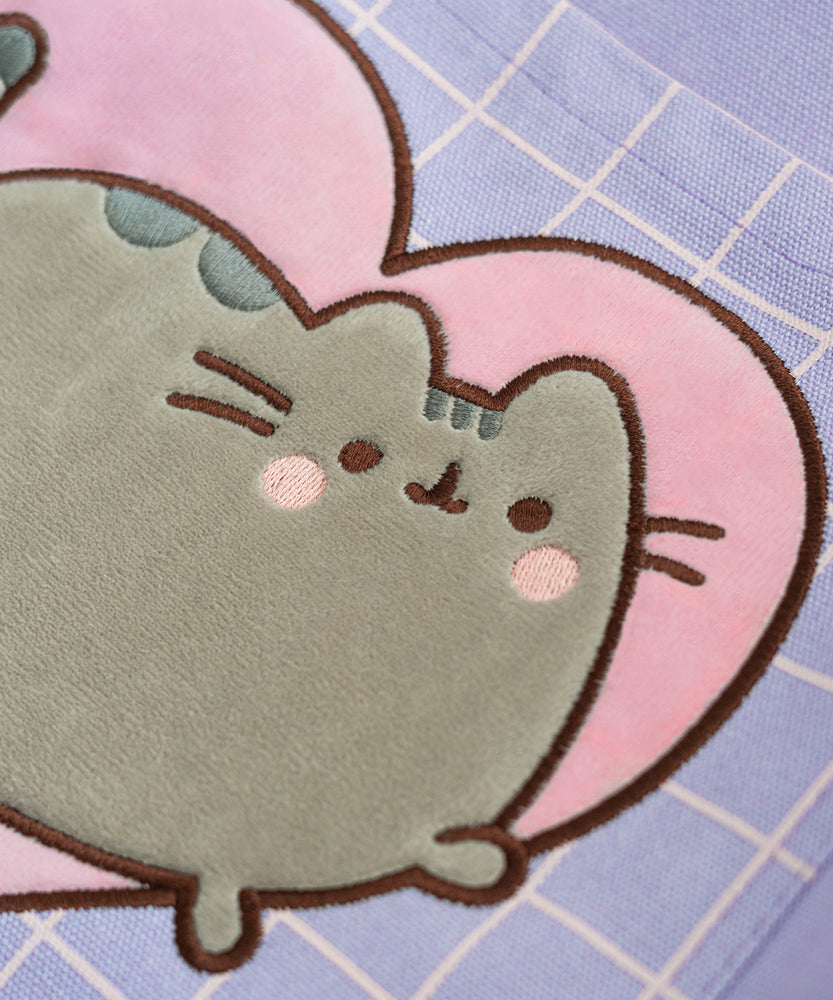 Close-up view of the Pusheen applique on the front pocket. The grey velour appliqué of Pusheen shows the cat blushing with surrounded by a heart and grid pattern.