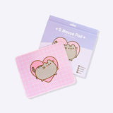 The pink with white grid pattern Pusheen Mouse Pad sits in front of its purple packaging. The packaging shows the size of the mouse pad as well as listing its features: waterproof, durability, precision, and speed. 