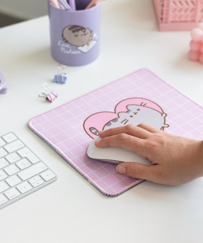 Model holds onto a computer mouse that sits on top of the Pusheen Mouse Pad.