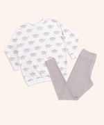 Close-up view of the Pusheen Loungewear Top’s all over print. The graphics of Pusheen the Cat show her grey standing body and leggings accented with brown features: tail stripes, back stripes, head stripes, eyes, mouth, and whiskers. 