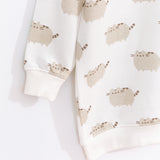 Close-up view of the Pusheen tunic top’s sleeve and hem ribbed detailing. The cream-colored top is edged with a ribbed cream finish at the collar, cuffs, and hem.  