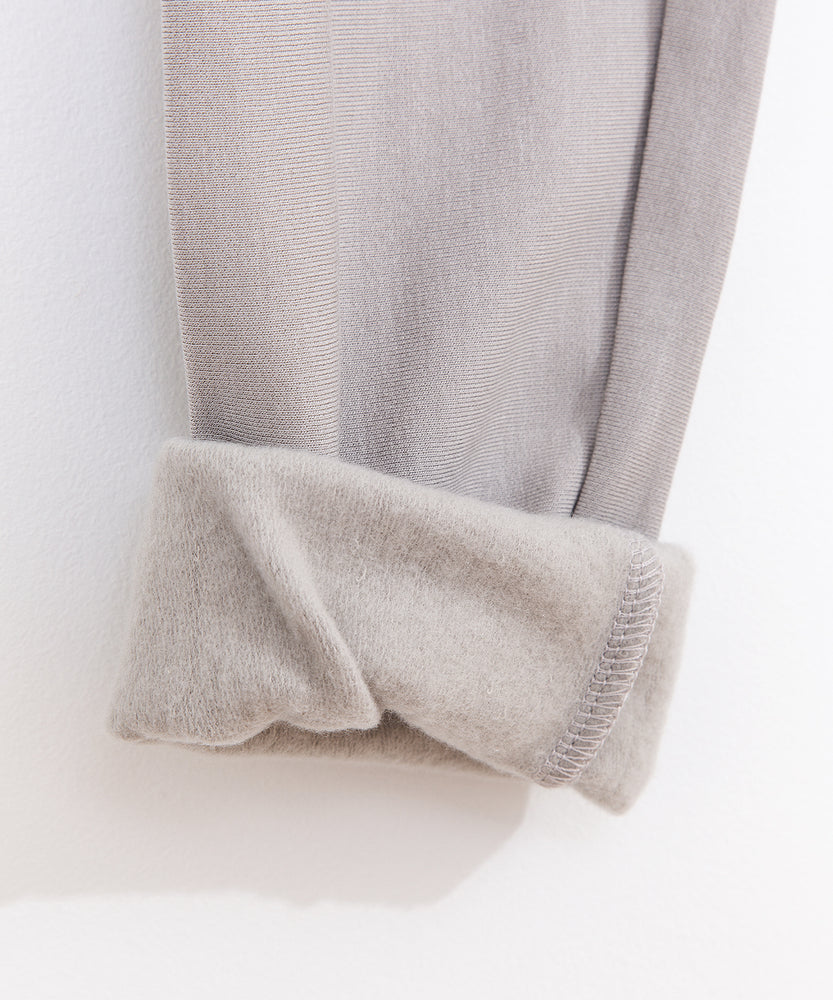 Close-up view of the interior of the leggings. The taupe bottoms have a soft taupe-colored interior lining. 