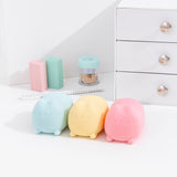 Blue, yellow, and pink Pusheen toys sit in front of stationery and desk items.