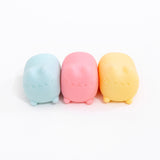 Pusheen Surprise Squishu Assortment of toys. From left to right are blue, pink, and yellow variations of gel-filled toys that resemble Pusheen the Cat.
