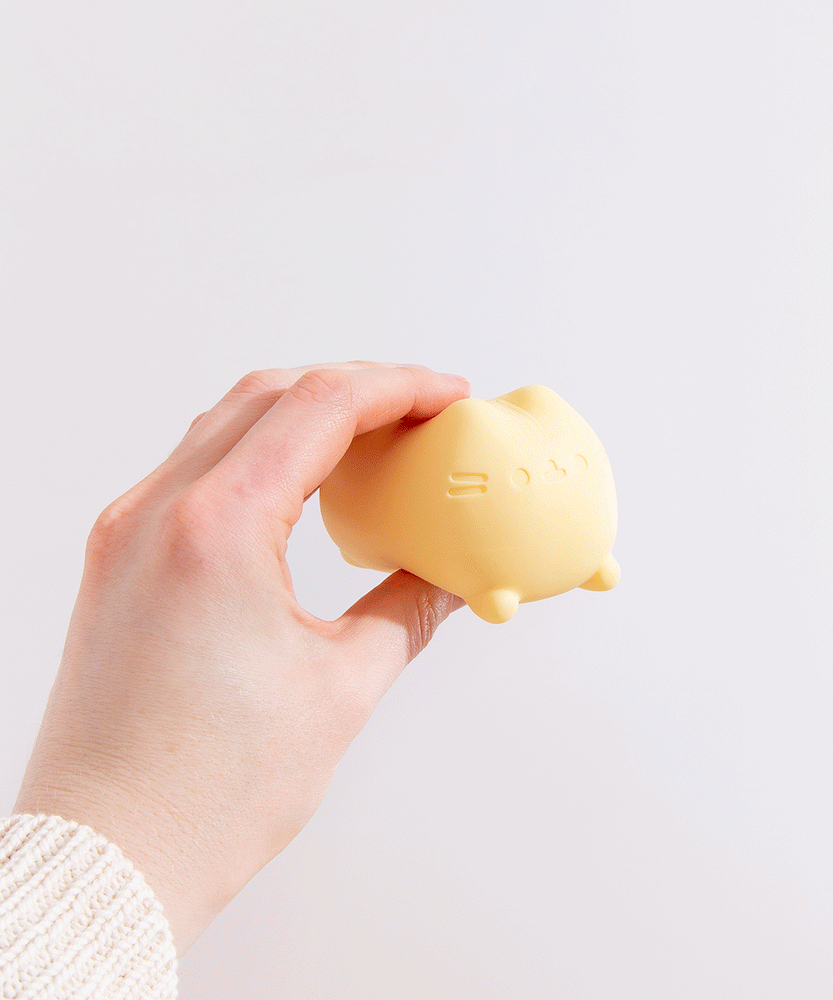 Side and back view of the Pusheen Surprise Squishy Toy Assormtnet. Pusheen's striped tail is engraved at the back of the toy.