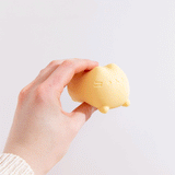 Model squishes yellow squishy toy with fingers. The gel-filled toy squishes like a stress ball.