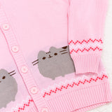 Close-up view of Pusheen knit detail. Also featured in the photo is a close-up of the cuff and hem of the pink unisex knit cardigan. The cuff and hem have a pink ribbed edge that matches the rest of the cardigan color.  