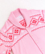 Close-up view of the diamond and heart print at the top of the cardigan. The cardigan has fold over lapels that match the ribbed hem and cuffs. The pattern features a variety of diamonds, hearts, and squiggles.  