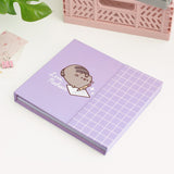 Front cover of the weekly planner. The purple binder features a graphic of a gray and brown cat writing a note with the phrase "love, Pusheen" underneath the cat.