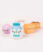 Close-up view of the milk bottle Surprise Squishy. On each squishy, Pusheen's ears partially extend off the front of the figure above the printed features of Pusheen's face.