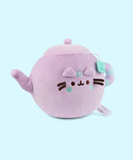 Side quarter view of the Teapot plush. Pusheen's spot lid and body color are all lilac while her tail mimic the handle of the tea pot. The handle is striped lilac and light mint green.