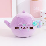 Front view of the Pusheen's Kitchen Teapot Squisheen Plush. The lilac colored plush shows Pusheen the Cat taking the form of a classic tea kettle with a tea bag label coming out of the lid.