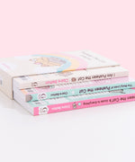 I Am Pusheen the Cat, The Many Lives of Pusheen the Cat, and Pusheen the Cat's Guide to Everything Paperback books stacked atop one another inside the decorative book box. Books lie upside down inside the box to show the spine graphics and portions of the back covers of each book.  