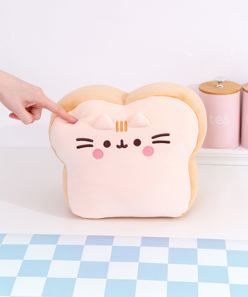 Back view of the Pusheen's Kitchen White Bread Squisheen Plush. The back of the bread slice plush features Pusheen's two back stripes that matches the light-brown color of the side of plush. Towards the bottom of the plush is Pusheen's striped tail alternating the colors of light cream and light brown.