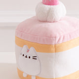 Close-up of the Pusheen plush on the Cake Squisheen. Pusheen's eyes, nose, and whiskers are embroidered in black while her three head stripes are a medium pink embroidery color.