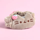 Front view of the Pusheen Spa Headband. The soft plush headband features Pusheen face embroidered in brown as well as a small plush strawberry.