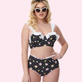 Model wears the Pusheen Tropical Fruit Bikini Set. The black swimsuit features an all over print of Pusheen and Stormy in pool floaties surrounded by white polka dots and tropical fruits.