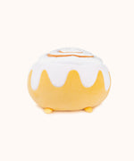 A back view of the Cinnamon Bun Squisheen, with the rim of the frosting going around the back. The plush does not have a tail. Pusheen's feet peek out from the bottom.