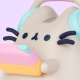 Close-up view of Gaming Lamp. The plastic lamp features Pusheen’s whiskers and paws as well as headphones and a gaming device that extend off the plastic body.  
