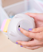 Model indicating the on/off switch of the Pusheen Gaming Lamp. The lamp can be powered via USB-C cord or with batteries.  