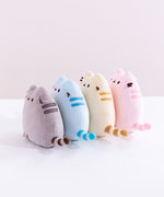 A model’s hand squeezing the grey Mini Squisheen Plush, demonstrating it’s squishiness.