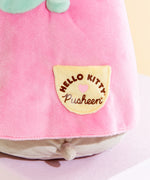 Close up of the Hello Kitty x Pusheen collaboration logo screen printed on the dress pocket. The logo features Hello Kitty's logo curved over a pink heart, with Pusheen's logo underneath the heart.