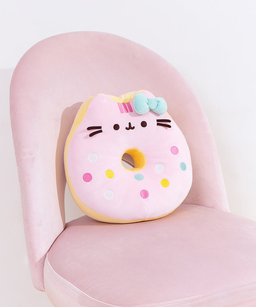 Pusheen side of the reversible Donut Plush. Pusheen’s stripes have turned pink, but she keeps her classic black eyes, nose, and whiskers while taking the form of a strawberry glazed donut. 