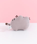 Back view of Knit Pusheen Plush. In this view, the front whiskers can be seen extending off the front of the plush. The plush sits atop little, crocheted paws. 