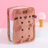 Front and side view of the Neapolitan Ice Cream Sandwich Pusheen Squisheen Plush. Pusheen takes the form of a tri-colored ice cream dessert. The rectangle shaped plush has brown “sandwich” pieces with dark brown circles to indicate holes. Pusheen’s face is is embroidered in a matching dark brown thread color. 