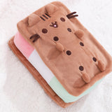Side aerial view of the Ice Cream plush. In this view, the inner strawberry, vanilla, and pistachio ice creams are shown. On top of the Squisheen, Pusheen’s brown whiskers extend off her rectangular body.  