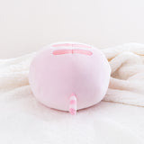 Back view of the Pink Round Squisheen sitting on top a fluffy white blanket. All the stripes on Pink Pusheen are a dark pink.