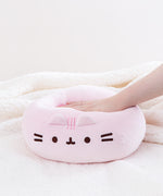 A model’s hand pressing down on the Pink Round Squisheen, demonstrating the plush’s squishiness. 