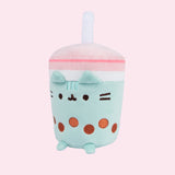 Front view of the Boba Tea Sips Plush with a slight side profile. Plush is accentuated by a light pink background. 
