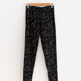 The Pusheen Celestial Leggings hanging from a wooden hanger in front of a white background.