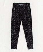 Front view of the Pusheen Celestial Leggings, on top of a white fuzzy blanket.