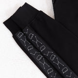 Close up of the ribbed knit ankle cuff of the jogger. The strip of fabric with the pattern on the side of the jogger is made of slightly different material from the rest of the jogger and has a faint sheen the rest of the jogger lacks.