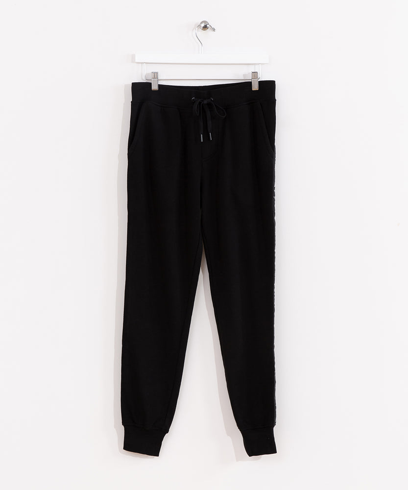 Front view of the Pusheen Celestial Jogger, hanging from a white clothes hanger in front of a white background. The pattern on the side is not visible from the front, making the item appear like a solid black jogger.
