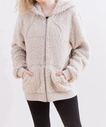 Model wearing the Pusheen Character hoodie with their hands in the pockets. The fuzzy hoodie fits loosely on the arms, while the ribbed cuffs fit more closely. 