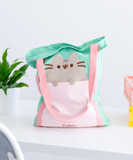 Back view of Pusheen Deluxe Tote Bag. The mint tote bag has pink handles that extend down the entire body of the bag. 