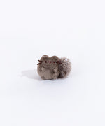 Full view of the mini skunk plush from the collectors set. The skunk resembles Pusheen, but with dark grey fur and a fluffy black tail with a stripe of white felt on top.