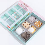 The mini plush inside of their original packaging, with the front sleeve laid down besides it.